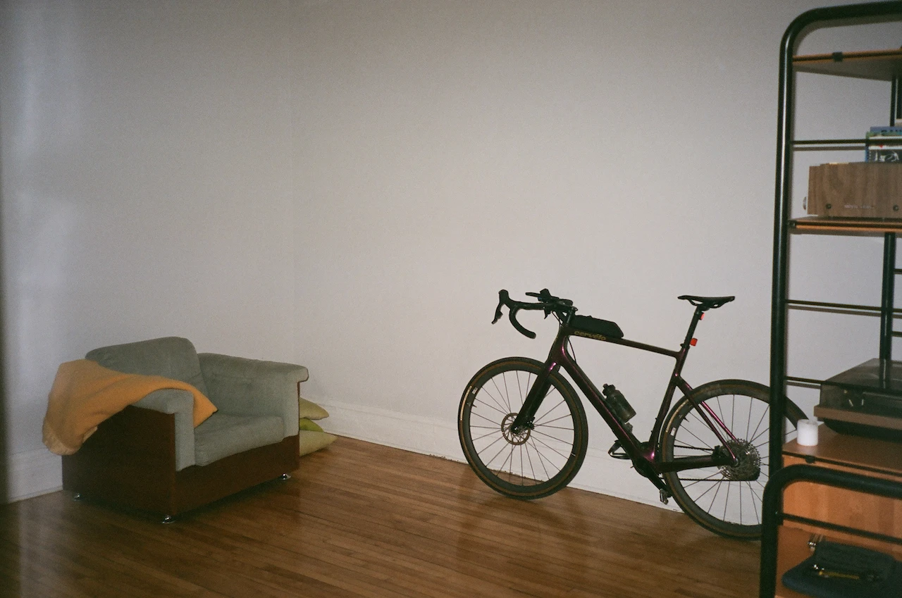 A black bicycle leaning beside a window in a quiet room