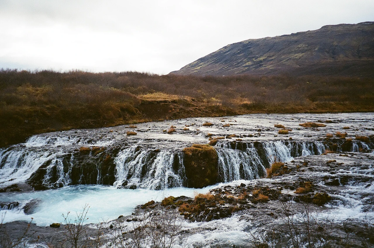 A broad waterfall running over dark layered stone