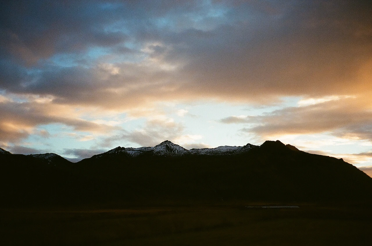 A dark mountain ridge under the last orange light of day