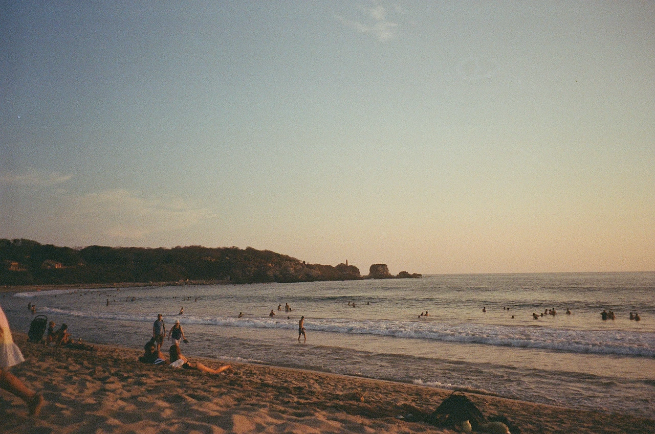 A broad beach at low tide beneath a pale evening sky
